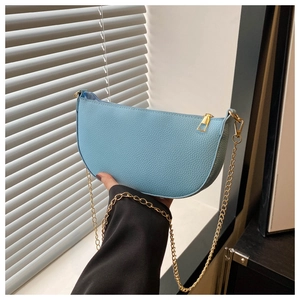 Detail der hellblauen Tasche mit Lychee-Prägung, goldener Kette und Reißverschluss