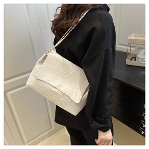 Détail du sac à bandoulière blanc tissé avec chaîne dorée élégante sur un mannequin