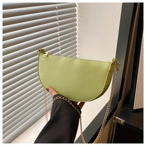 Detail der avocadogrünen Satteltasche in Halbmondform mit Lederstruktur und Goldkette