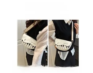 Détail d'un sac selle blanc avec imprimé piano montrant les styles épaule et bandoulière
