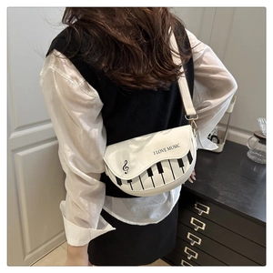 Détail du motif clavier de piano sur un petit sac à bandoulière blanc pour femmes