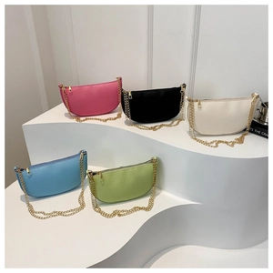 Detail of crescent crossbody bags in multiple colors with chain straps and gold zippers