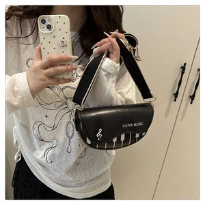 Détail du sac bandoulière thème musique avec motif touches de piano et sangle bicolore