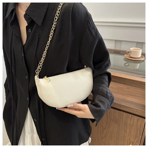Detail of crescent shoulder bag featuring lychee texture and gold metal chain strap