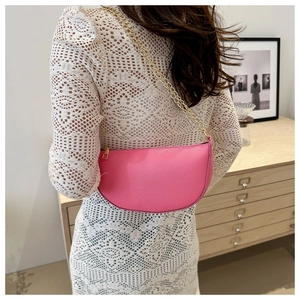 Pink crescent shoulder bag with litchi texture and gold chain strap on model