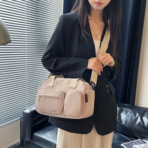 Minimalist apricot nylon Boston bag with multi-pockets and adjustable strap shown on model