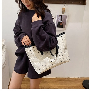 Détail du grand sac cabas blanc à pois avec motifs de nœuds noirs et fines anses