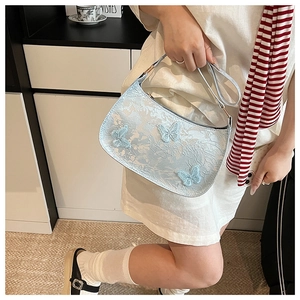 Dettaglio della borsa sottobraccio azzurra con jacquard floreale e farfalle in mesh 3D