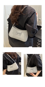 Detail der silbernen Glitzer-Achseltasche mit dekorativer Schleife und Metallic-Struktur