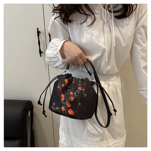 Detail of black drawstring bucket bag with traditional persimmon branch and calligraphy