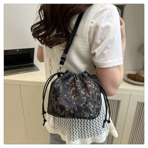 Close-up of drawstring bucket bag with vintage floral print and adjustable strap