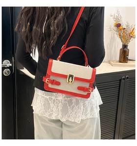 Detail of red and white color-block flap bag with vintage gold metal buckle and strap