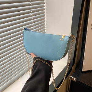 Hellblaue Halbmondtasche aus Kieselleder mit goldener Kette im minimalistischen Stil