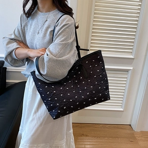 Grand sac cabas noir avec motifs de nœuds blancs et texture matelassée élégante
