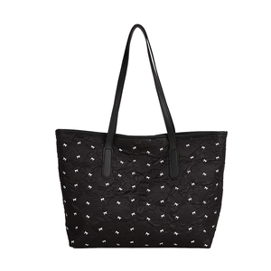 Grand sac fourre-tout noir matelassé avec motif à nœuds blancs et bandoulières en cuir
