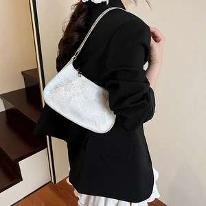 Elegante borsa baguette bianca con ricamo a farfalla indossata da una modella