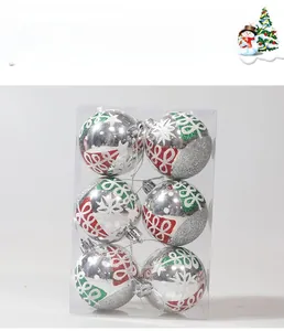 Macro detail of silver Christmas ball set with hand-painted red and green snowflake patterns