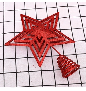 Close-up of red glitter Christmas tree topper star with metal spiral spring base