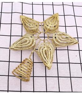 Close-up of golden glittery star tree topper with hollow design and spiral base