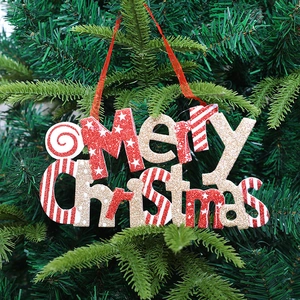 Sparkly Merry Christmas letter sign hanging on a green tree branch with red ribbon