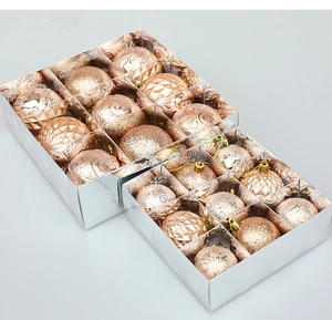 Détail macro de boules de Noël or rose avec textures pailletées et spirales en boîtes argent