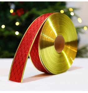 Macro view of red festive ribbon with gold edges and textured diamond pattern detail