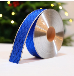 Close-up of blue festive ribbon with silver edges on a roll for gift wrapping
