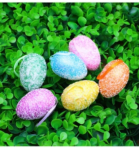 Detailed view of six colorful textured Easter eggs with ribbons on green artificial grass