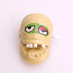 Halloween wind-up mummy head toy with green face and red eyes for party favors