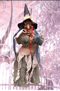 Detail of Halloween witch hanging decor with pointed hat, green robe and gray hair