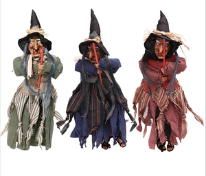 Three hanging Halloween witch dolls with colorful striped skirts and brooms for decor