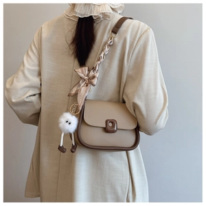 Détail de sac bandoulière avec bandoulière foulard en soie et breloque peluche décorative