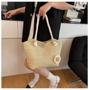 Detail of hand-woven tote bag with cotton rope handles and sunflower decoration
