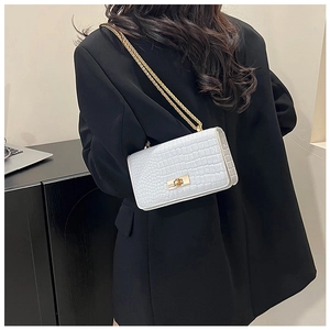 White faux leather crossbody bag with stone pattern and gold chain on model