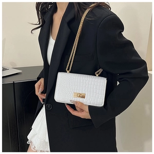 Close-up of white crocodile pattern shoulder bag with elegant gold metal twist lock