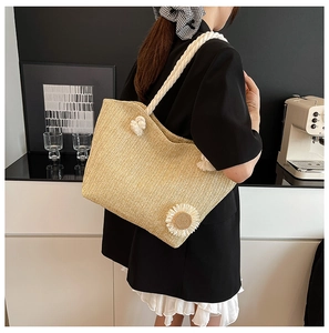 Straw bucket tote bag featuring white woven rope handles and a daisy flower applique detail