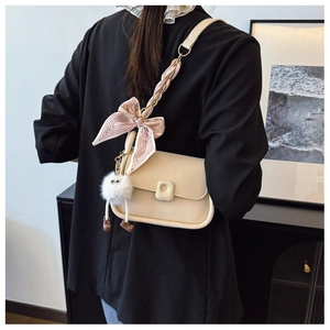 Détail du sac à bandoulière crème avec nœud en soie et pendentif peluche mignon