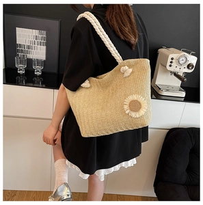 Detail of beige straw bucket bag featuring a 3D sunflower and thick rope handle