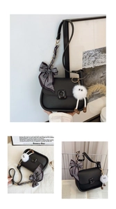 Detail of black matte square bag with striped ribbon bow and plush monster pendant charm