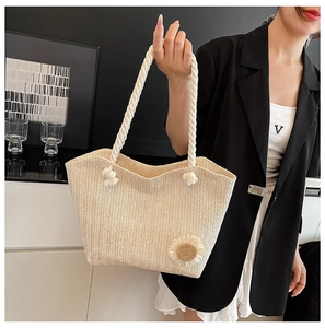 Detail of cream woven tote bag featuring a 3D sunflower and thick rope handles