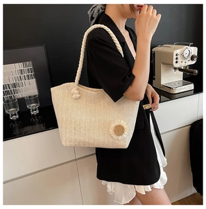 Detail of hand-woven beige tote bag with a white sunflower and thick cotton rope handle