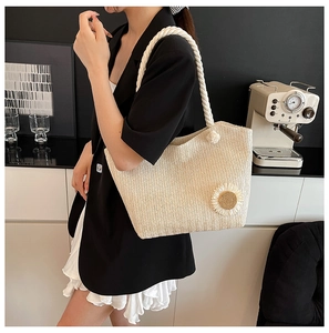 Detailed close-up of straw bucket bag featuring a 3D sunflower and thick rope strap