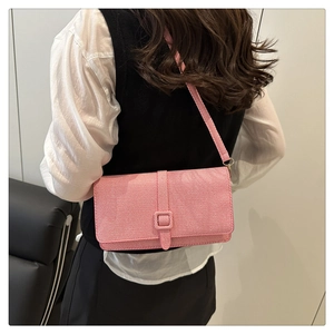 Vue latérale d'un sac bandoulière en toile à rayures roses et blanches sur mannequin