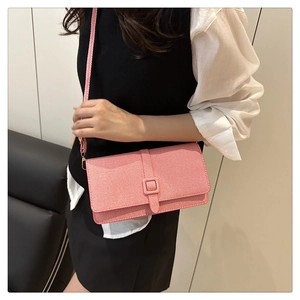 Modèle portant un sac bandoulière à rayures roses et blanches avec boucle carrée