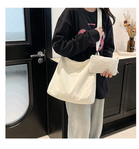 Detail of white corduroy tote bag and small pouch set with leather brand patch