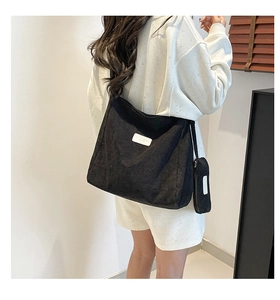 Detail of black corduroy hobo shoulder bag with a small zipper pouch for coins