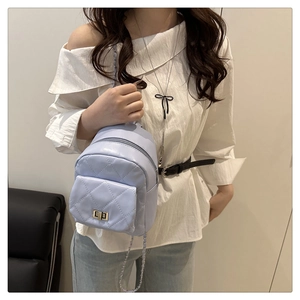 Close-up of quilted lilac mini backpack with gold twist lock and chain strap