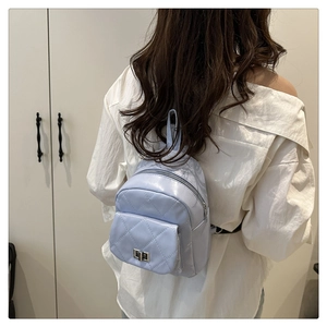 Quilted lavender mini backpack with silver twist lock shown on a model's back