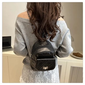 Quilted black mini backpack with silver twist lock shown in a casual lifestyle setting