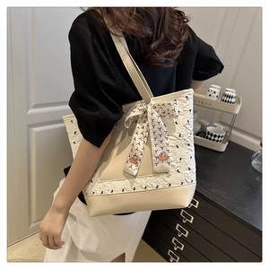 Détail d'un grand sac cabas beige avec surpiqûres florales, foulard en soie et cuir PU lisse